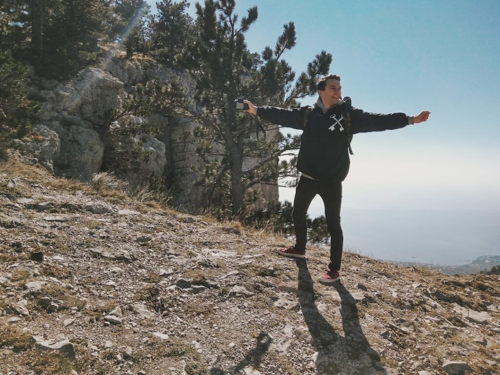 Hombre joven disfrutando de un bello paisaje con los brazos abiertos